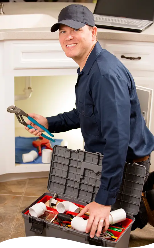 Plumbing technician working under a sink